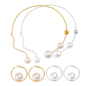 Auffälliges Perlen-Schmuckset mit Gold- und Silberhalsreifen sowie großen Creolen
