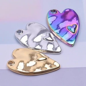 Close-up of hammered heart pendants in gold, silver, and rainbow steel finish