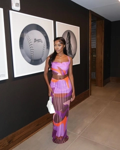 Detail of purple and orange geometric print on pleated two-piece set with long skirt