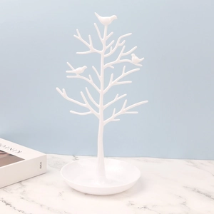 Dettaglio portagioie a forma di albero con uccellini e base in marmo bianco testurizzato