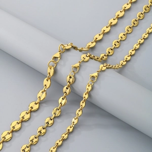 Detailed view of 18K gold plated stainless steel coffee bean link chains on grey display