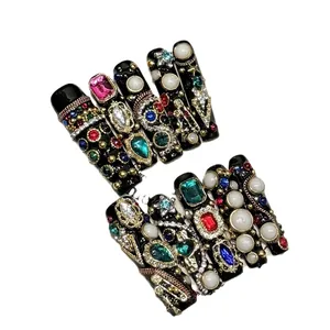 Luxurious handmade press-on nails with colorful rhinestones and gold vintage chains on black