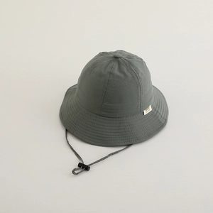 Détail d'un chapeau bob enfant vert foncé avec tissu texturé et cordon de serrage réglable