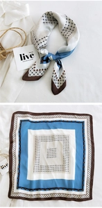 Detail of geometric plaid silk scarf in blue and brown styled with a white shirt