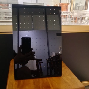 L-shaped black acrylic jewelry stand for earrings on a rustic wooden base