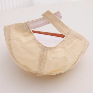 Gros plan sur la sangle velcro réglable et les coutures d'une casquette beige enfant