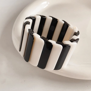 Close-up of minimalist black and white striped resin ring on a ceramic plate