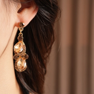 Gros plan de boucles d'oreilles vintage en or champagne avec cristaux en goutte d'eau