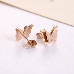 Close-up of 3D butterfly earrings in rose gold with polished and frosted wing details