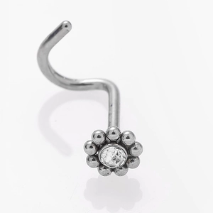 Macro shot of silver flower nose stud with clear zircon crystal and curved S-bar pin