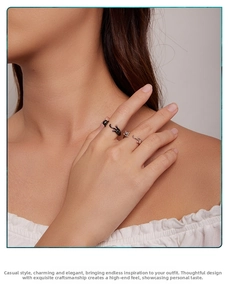 Close-up of black and silver cat open rings worn by a model on fingers