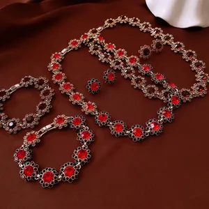 Luxury flower jewelry set with red crystals and black rhinestones on dark red silk background