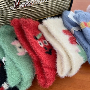 Plush mink velvet socks in various colors stacked on a desk for winter warmth