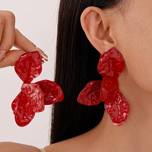 Exaggerated red floral petal earrings with pleated texture and glossy paint finish