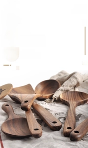 Detailed macro view of polished acacia wood kitchen spatula with natural wood grain texture