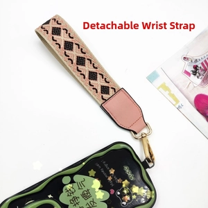 Detail of detachable pink fabric wrist strap with ethnic embroidery and gold metal lobster clasp