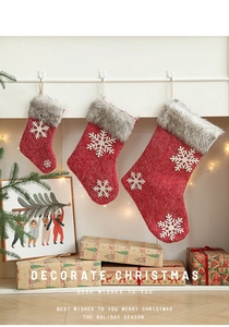 Detailed view of red Christmas stockings in three sizes with white snowflakes and fur trim