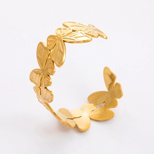 Detailed view of the 18k gold plated stainless steel open bangle with butterfly motifs