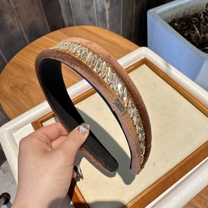 Détails du serre-tête en velours marron avec strass et étiquette métallique