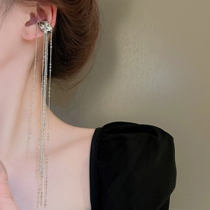 Close-up of silver tassel chain ear cuff on model, featuring irregular C-shape design