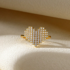 Macro detail of a pixelated heart-shaped gold ring with shimmering cubic zirconia micro-pavé