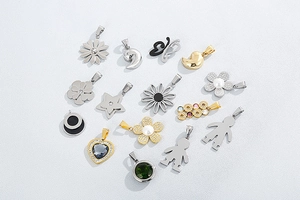 Flat lay of diverse stainless steel charms including daisy, star, and heart patterns
