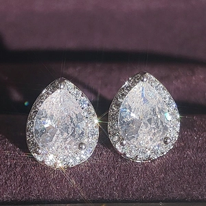 Elegant pear shaped halo stud earrings with brilliant drop cut stones in silver setting