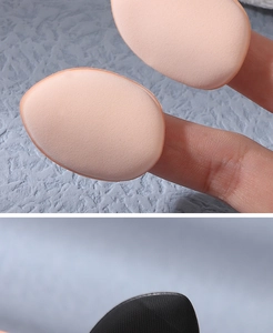 Detailed macro view of mini finger teardrop makeup puffs in beige and black colors