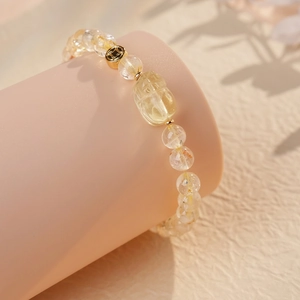 Polished citrine beaded bracelet with golden coin charm and carved mythical beast bead