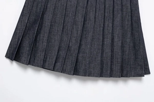 Detailed view of dark blue denim pleated hem with crisp folds and twill texture