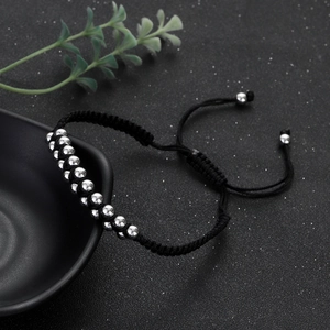 Close-up of adjustable double-row silver beads on a woven black hip hop style bracelet