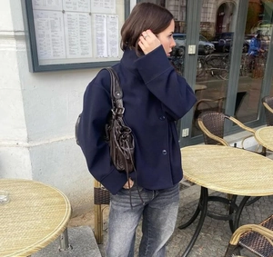 Court manteau bleu marine pour femme style urbain avec jean gris et sac à bandoulière