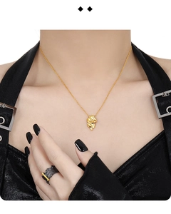 Detail of gold lava pendant necklace with irregular molten texture on black clothing