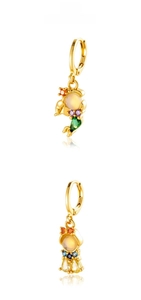 Close-up of gold plated mermaid tail huggie earrings with colorful zircon stones