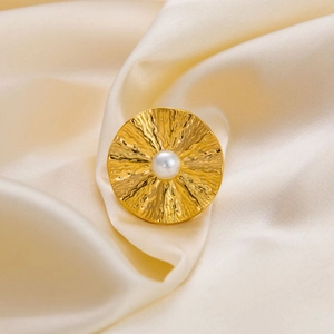 Hammered 18K gold plated stainless steel ring with a round white pearl on silk fabric