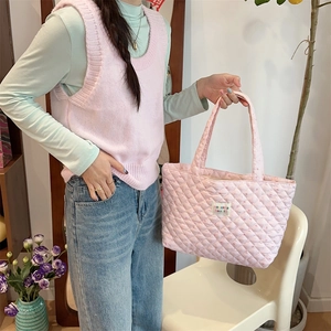 Detailed view of pink floral quilted cotton fabric and textured stitching on tote bag