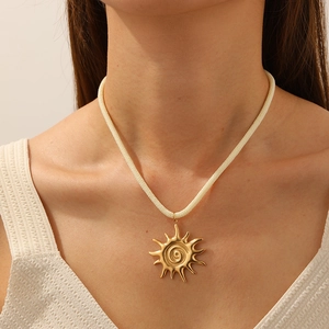 Vue détaillée du collier en corde épaisse avec pendentif soleil spirale doré