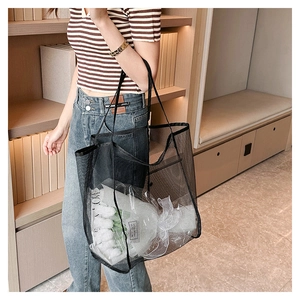Dettaglio borsa tote nera a rete con fiori freschi per uno stile di vita casual