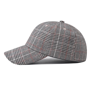 Detail of gray plaid baseball cap showing red and black check embroidery and texture