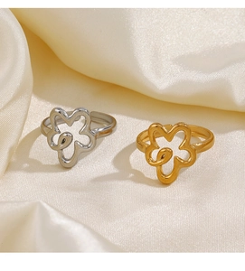 Detailed view of hollow flower rings in gold and silver finish on silk fabric