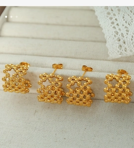 Detail of 18K gold-plated mesh sphere stud earrings with hollow beadwork texture