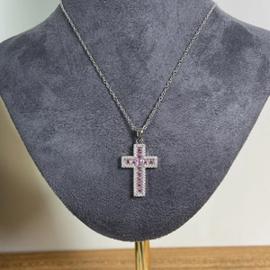 Collana a croce argento con micro-pietre rosa su un busto di manichino in velluto