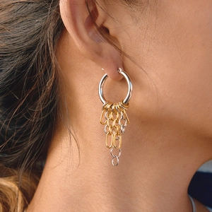 Close-up of interlocking gold and silver chain fringe on stainless steel hoop earrings