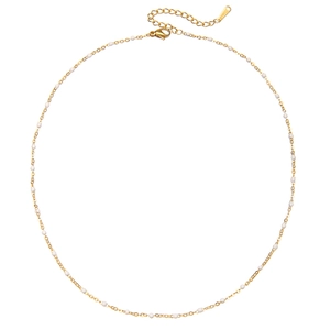 Detail of gold stainless steel necklace with white enamel beads and lobster clasp closure