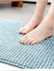 Close-up of thick light blue chenille bath mat showing superior water absorption