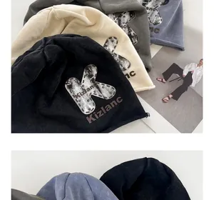Detail view of slouchy knit beanies with K-letter patch and rivet accents in four colors
