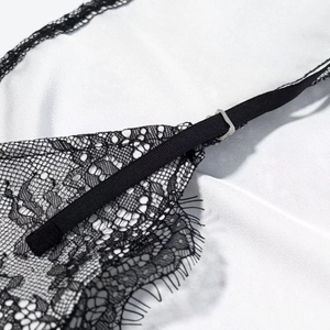 Détail de bretelles réglables avec boucles en métal sur une robe en dentelle noire