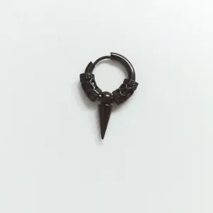 Detail macro of black stainless steel hoop earring with engraved pattern and spike pendant