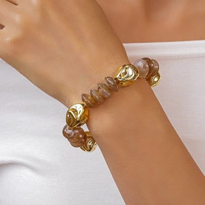 Macro detail of retro irregular gold metal beads and translucent brown acrylic beads bracelet