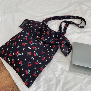 Détail du sac cabas en toile à imprimé cerises avec nœud volanté et texture douce